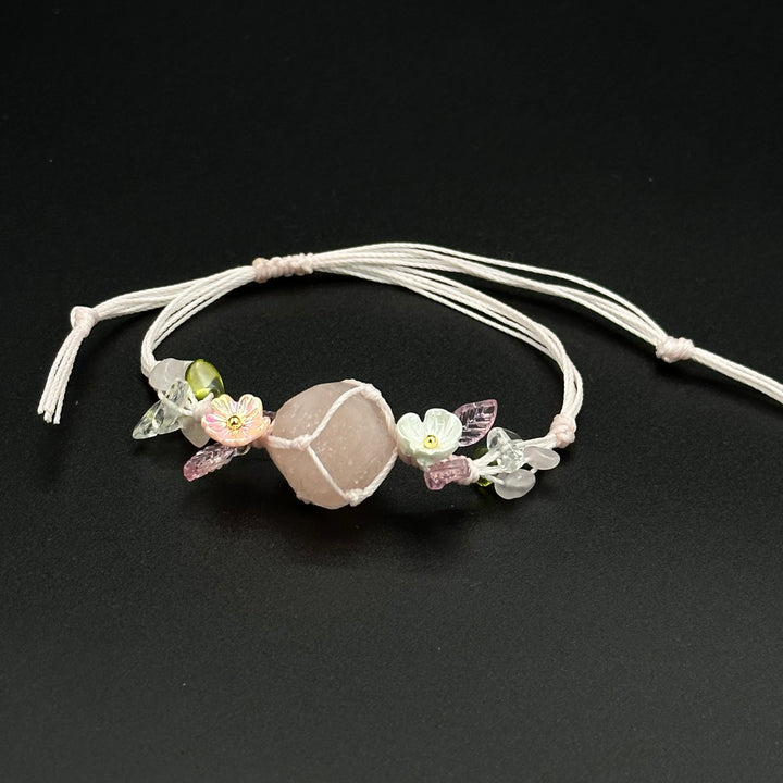 Rose Mist bracelet with pink and mixed-color blossom stones on a hand-braided cord