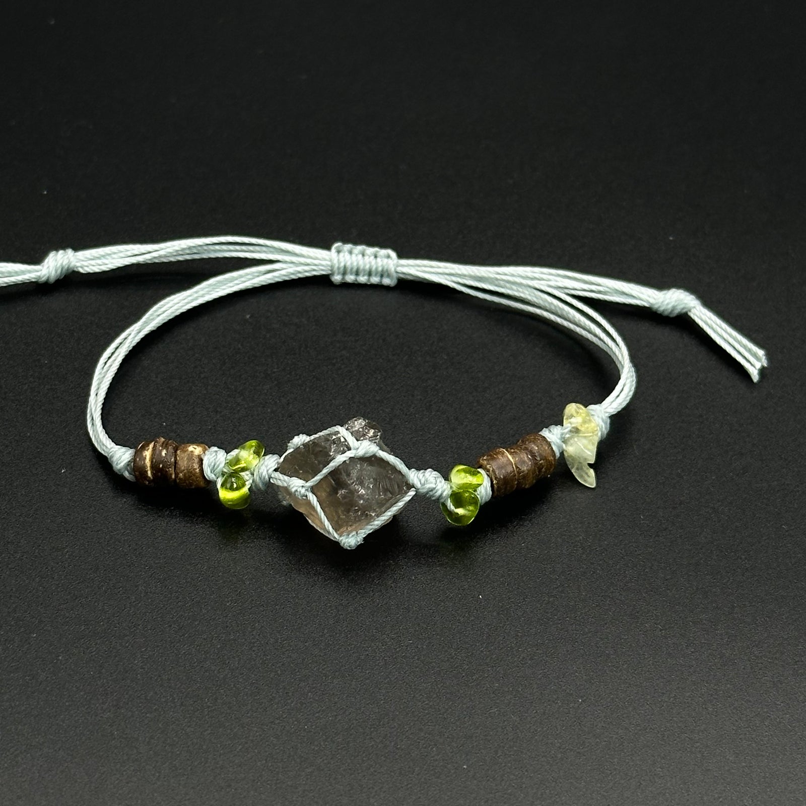 Moss Frost bracelet with cool blue, clear, and pale crystal accents on a braided cord