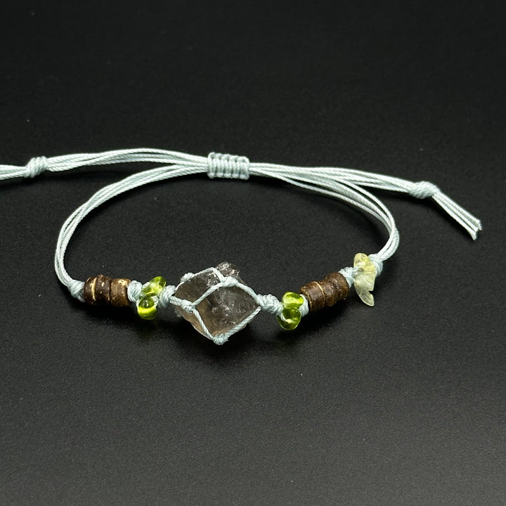 Moss Frost bracelet with cool blue, clear, and pale crystal accents on a braided cord