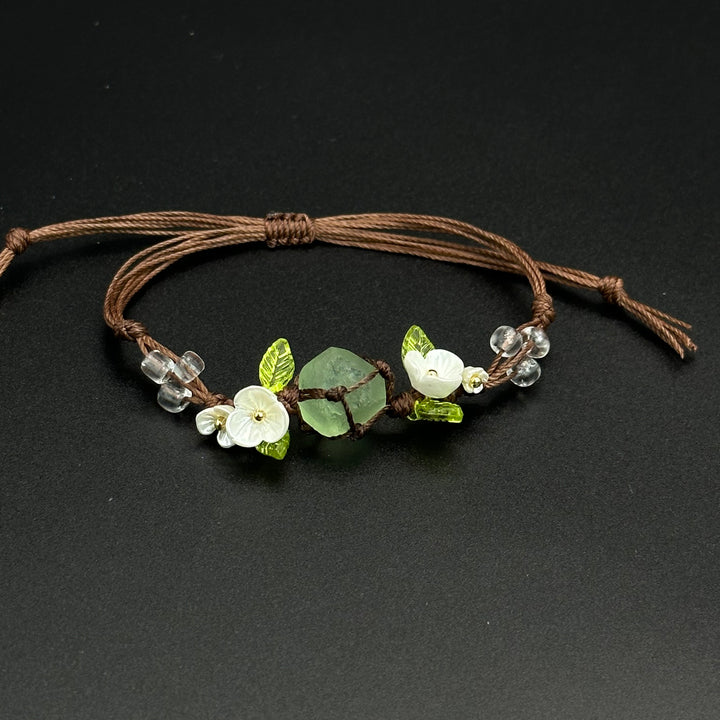 Lily Meadow bracelet with green and pale leaf-inspired crystals on a hand-braided cord